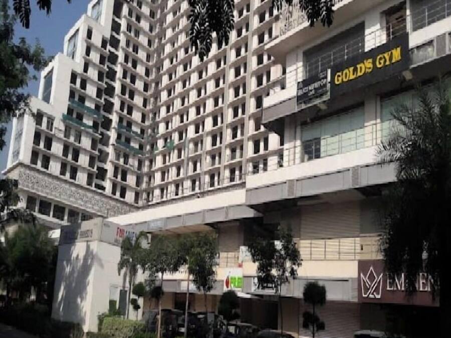 Um hotel com vários andares e design moderno, com destaque para uma academia bem equipada no térreo.