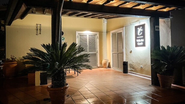 An outdoor area with a tiled floor, potted plants, and a sign indicating a restaurant. - Valle dei Casali (Rome)