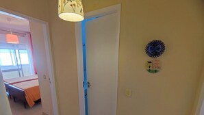 Un corridoio con un letto, una porta e un muro decorato con un piatto ornamentale.
