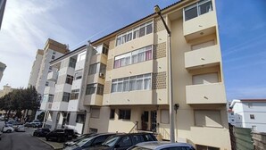 Un edificio residenziale a più piani con un'area di parcheggio antistante.