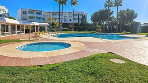 A resort with two swimming pools, a covered lounge area, and a building with multiple balconies. - Sunny Garden Apartment Miraflores (Mijas Costa)