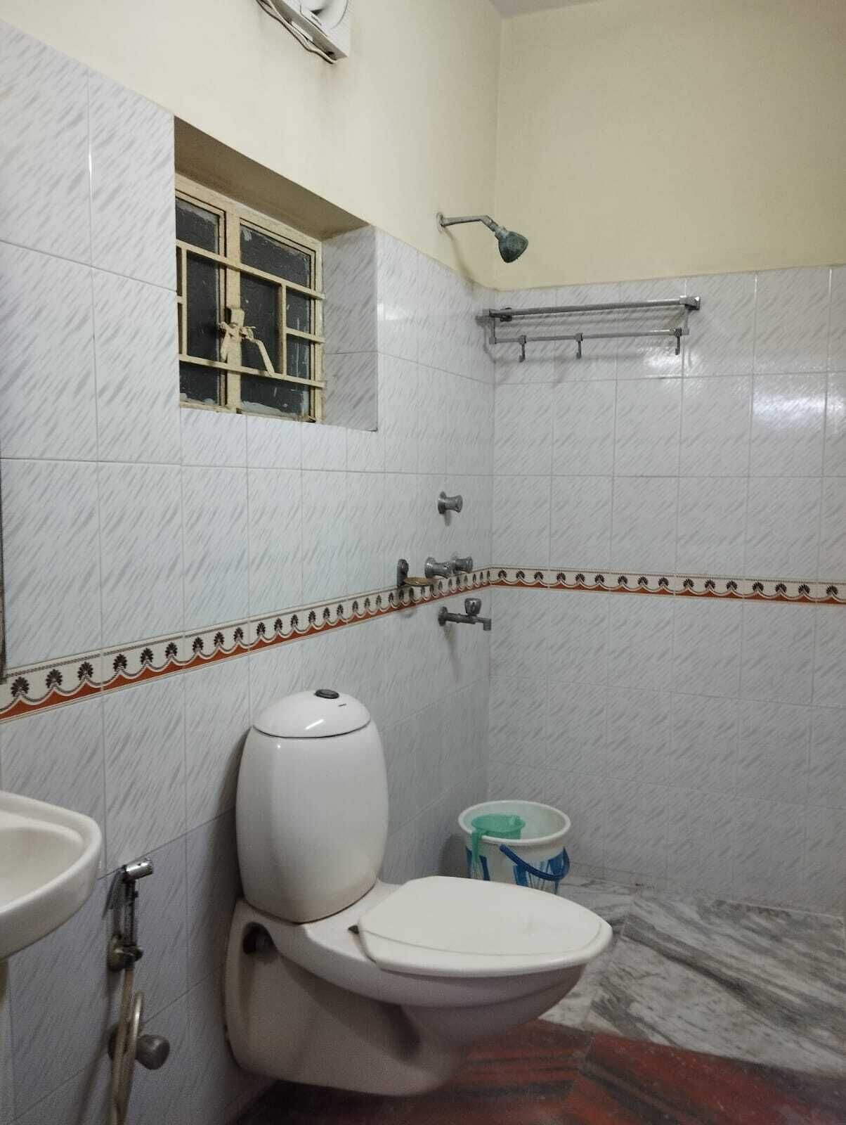 A small bathroom with a toilet, a sink, and a shower.