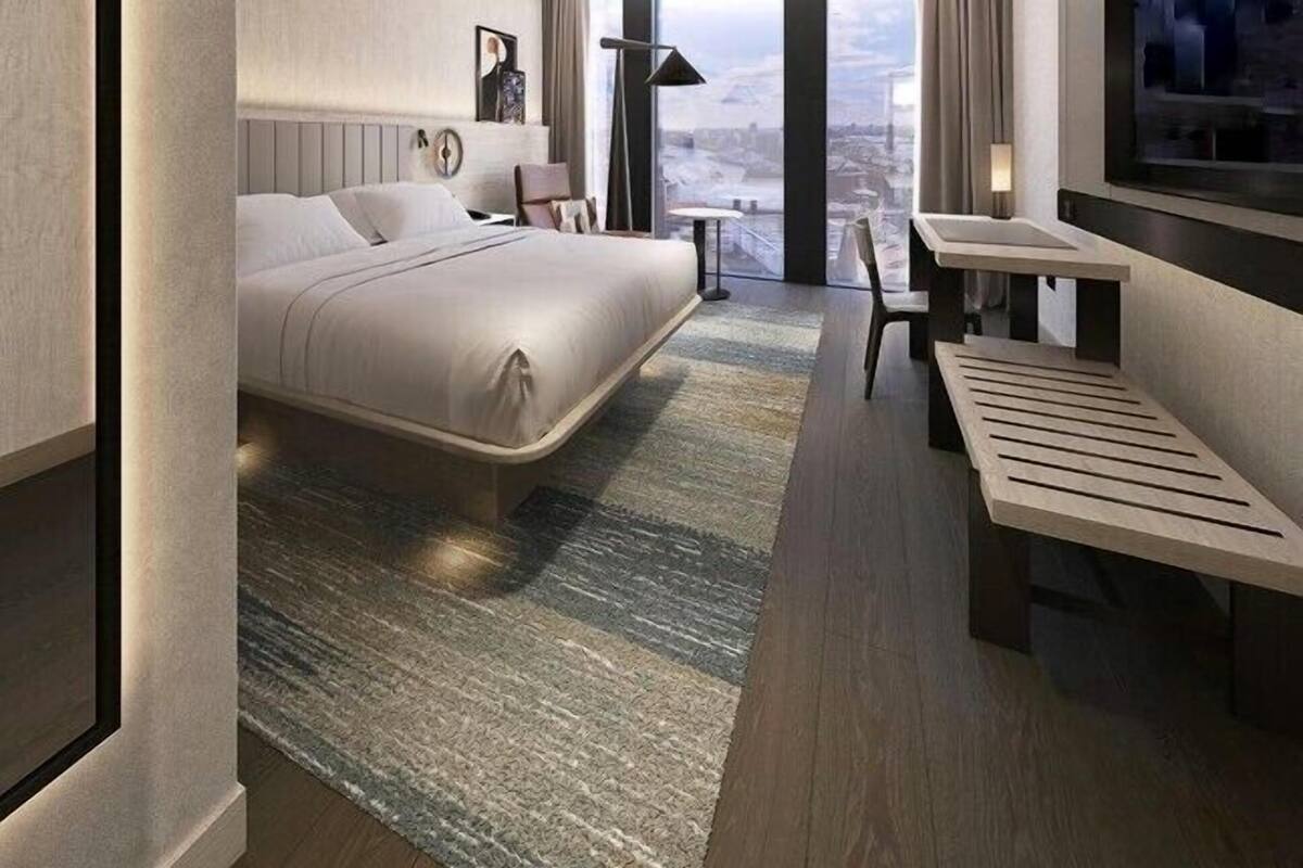 Une chambre d’hôtel moderne dotée d’un grand lit, d’un bureau, d’une chaise, d’une télévision et offrant une vue sur la ville.