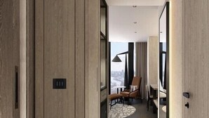 A modern hotel corridor with wooden paneling, a seating area with a table and chairs, and a view through a window. - ART Riverfront Hotel Tbilisi (Tbilisi)