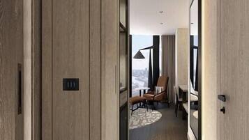 A modern hotel corridor with wooden paneling, a seating area with a table and chairs, and a view through a window.