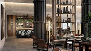 A spacious lobby with a bar area, seating arrangements, and a large plant. - ART Riverfront Hotel Tbilisi (Tbilisi)