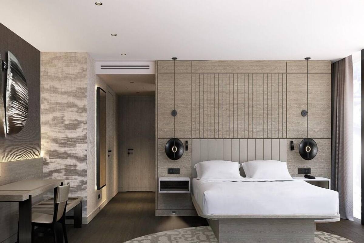 Une chambre à coucher moderne avec un lit, des tables de chevet, un bureau et une chaise.