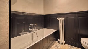 A bathroom with a freestanding bathtub, a toilet, and a radiator. - w Bright 2BR Near Arco Della Pace (Milan)