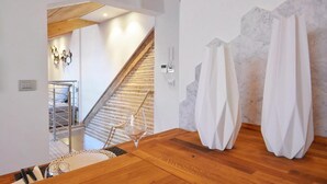 A staircase with wooden railings leading to a second floor, a wooden floor, and a white wall with a geometric pattern. - Address: Calle de le Ancore, 1044 - Castello BiennaleGoogle maps ' position: https://maps.app.goo.gl/ZF2iGXAu1hQr4UdG7The apartment is located on the third floor, consisting of a bedroom, bathroom with tub, living room with sofa bed for 2 people, kitchen (Venezia)