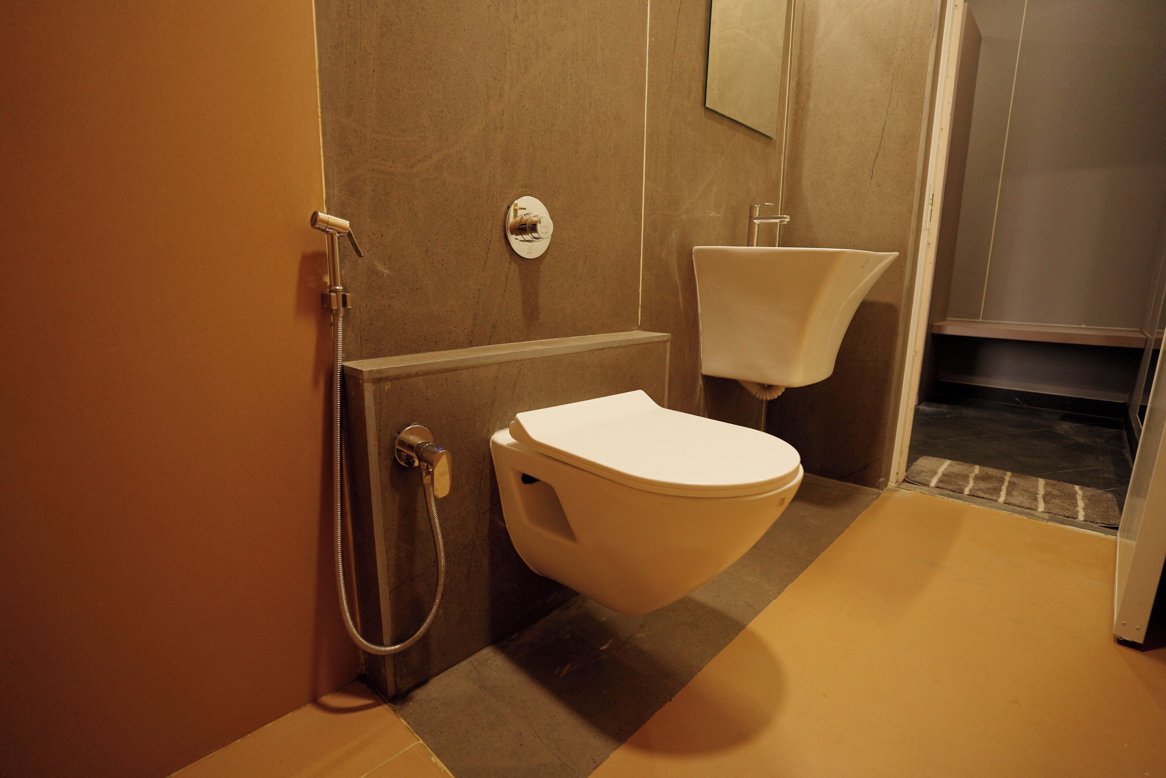 A bathroom with a toilet, a shower, and a sink.