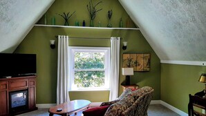 A living room with a television, a sofa, a coffee table, and a window with curtains. - Kettlestone (Stanton)