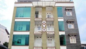 A multi-story hotel with balconies, large windows, and a prominent 'OYO' sign. - Collection O 294 Andrea Residence (Medan)
