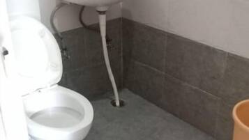 Un bagno con il water, un lavandino e pareti piastrellate.