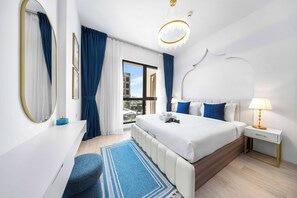 A modern hotel room with a large bed, a bedside table with a lamp, a large mirror, and a view of the city. - Stayshort - Bright 1 Bedroom in Madinat Jumeirah Living That Sleeps 2 With Balcony (Dubai)
