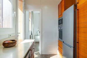 Una cocina moderna con un refrigerador grande, horno y ventana.