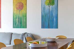 A dining area with a table, chairs, and a painting of a tree. - Penthouse with stunning TERRACE / Arco de Triunfo (08009 Barcelona)