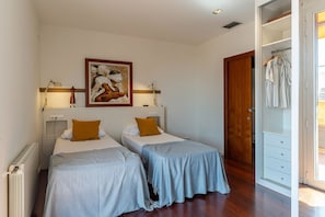 A hotel room with two beds, a wardrobe, and a painting on the wall. - Penthouse with stunning TERRACE / Arco de Triunfo (08009 Barcelona)