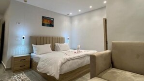 A modern bedroom with a bed, bedside table, and a nightstand. - Spacious King Room with Mountain View Near the Giza Pyramids (Nazlat as Sammān)