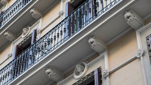 Un edificio de varios pisos con balcones ornamentados, molduras decorativas y detalles arquitectónicos de estilo clásico.