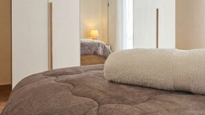 A bedroom with a large bed, a wardrobe with mirrored doors, and a visible bathroom with a shower curtain. - Apollo Apartment (Palermo)