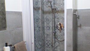 A bathroom with a shower enclosure, a sink, and a toilet. - Apollo Apartment (Palermo)