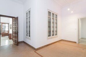 A room with a large wooden door, a window with decorative glass, and a plain white wall. - Unique & Stylish Townhouse / Paseo de Gracia (08037 Barcelona)