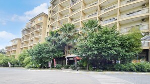 A multi-story hotel with balconies, surrounded by greenery and a clear sky. -  Palette - Gold Coast Morib Resort (Banting)