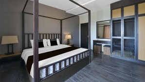 A four-poster bed with a dark wooden frame, a bedside table with a lamp, and a large mirror on the wall. -  Palette - Gold Coast Morib Resort (Banting)