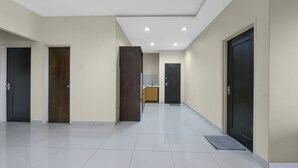 A spacious hallway with multiple doors, a kitchen area, and a tiled floor. -  Palette - Gold Coast Morib Resort (Banting)