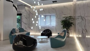 Un interior moderno con una zona de estar, un ventanal grande y una planta.