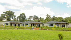 A row of modern houses with a flat roof, surrounded by a well-maintained lawn and trees. - Extreme Adventure Park (Busika)