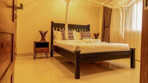 A bedroom with a bed, bedside tables, and a canopy. - Extreme Adventure Park (Busika)