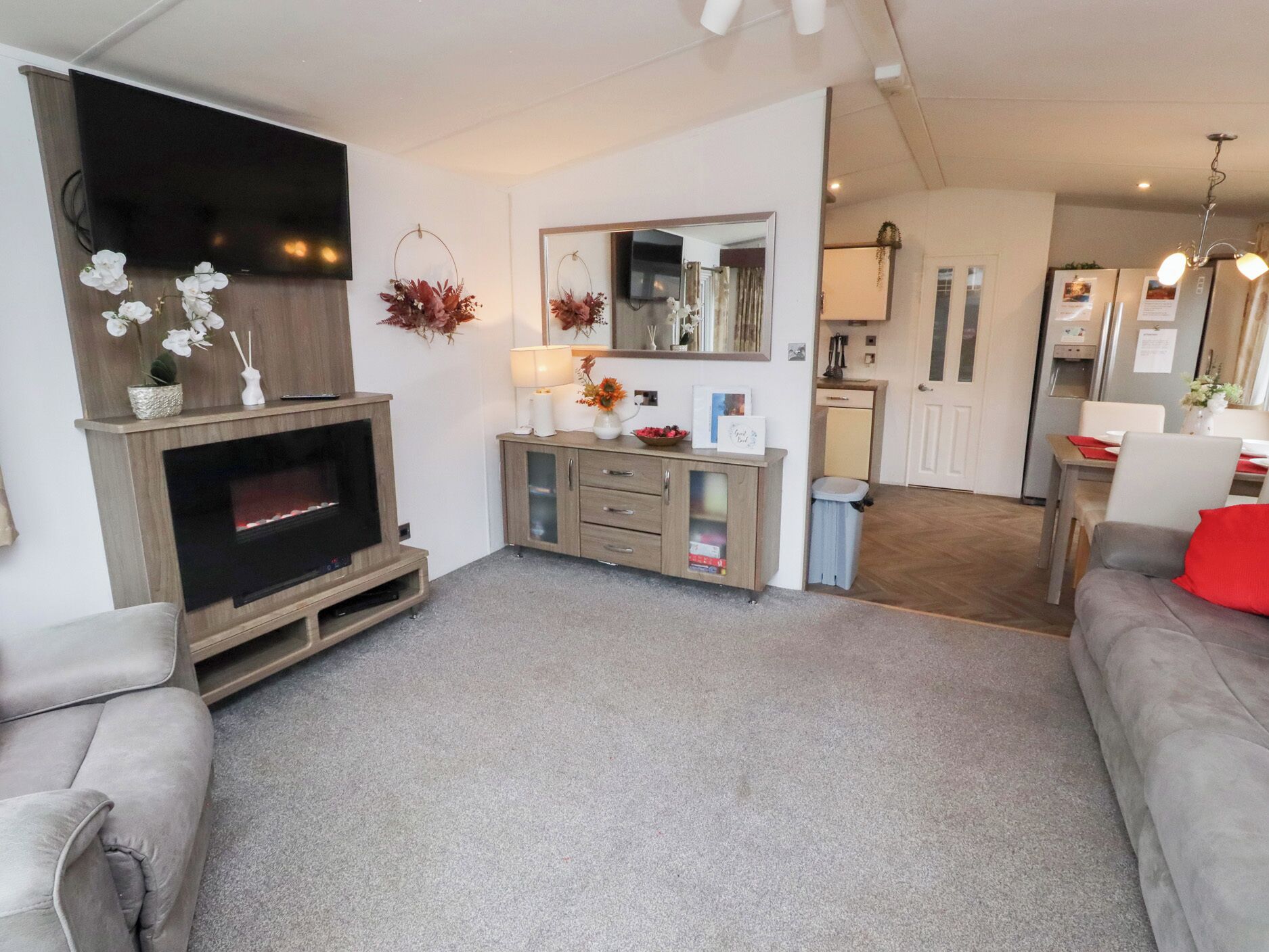 Una sala de estar con chimenea, un sofá, un televisor, un comedor y una cocina.