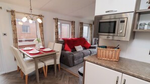 Un espacio habitable compacto con comedor, sofá y kitchenette.