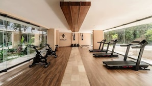 A gym with exercise equipment, a wooden floor, and large windows. - Narai Solecito House Tulum Jungle Views Aldea Zama (Tulum)