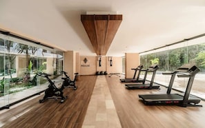 A gym with exercise equipment, a wooden floor, and large windows. - Narai Solecito House Tulum Jungle Views Aldea Zama (Tulum)