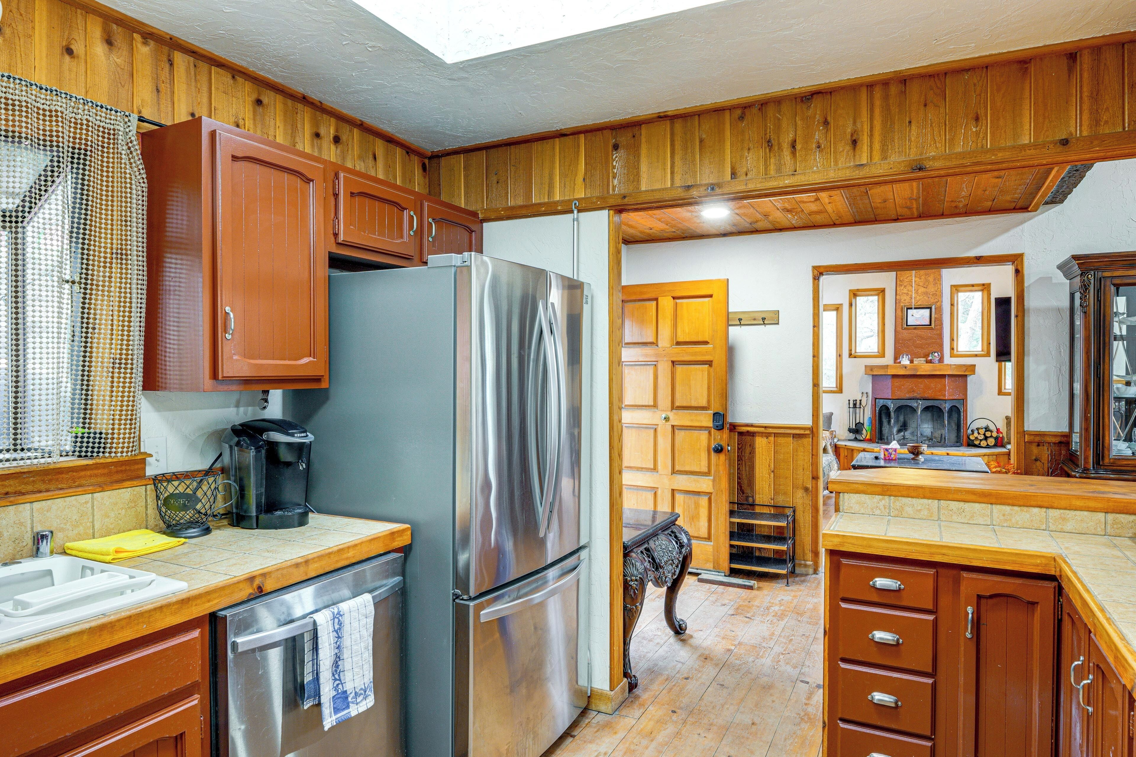 A kitchen with wooden cabinets, a stainless steel refrigerator, and a coffee maker.