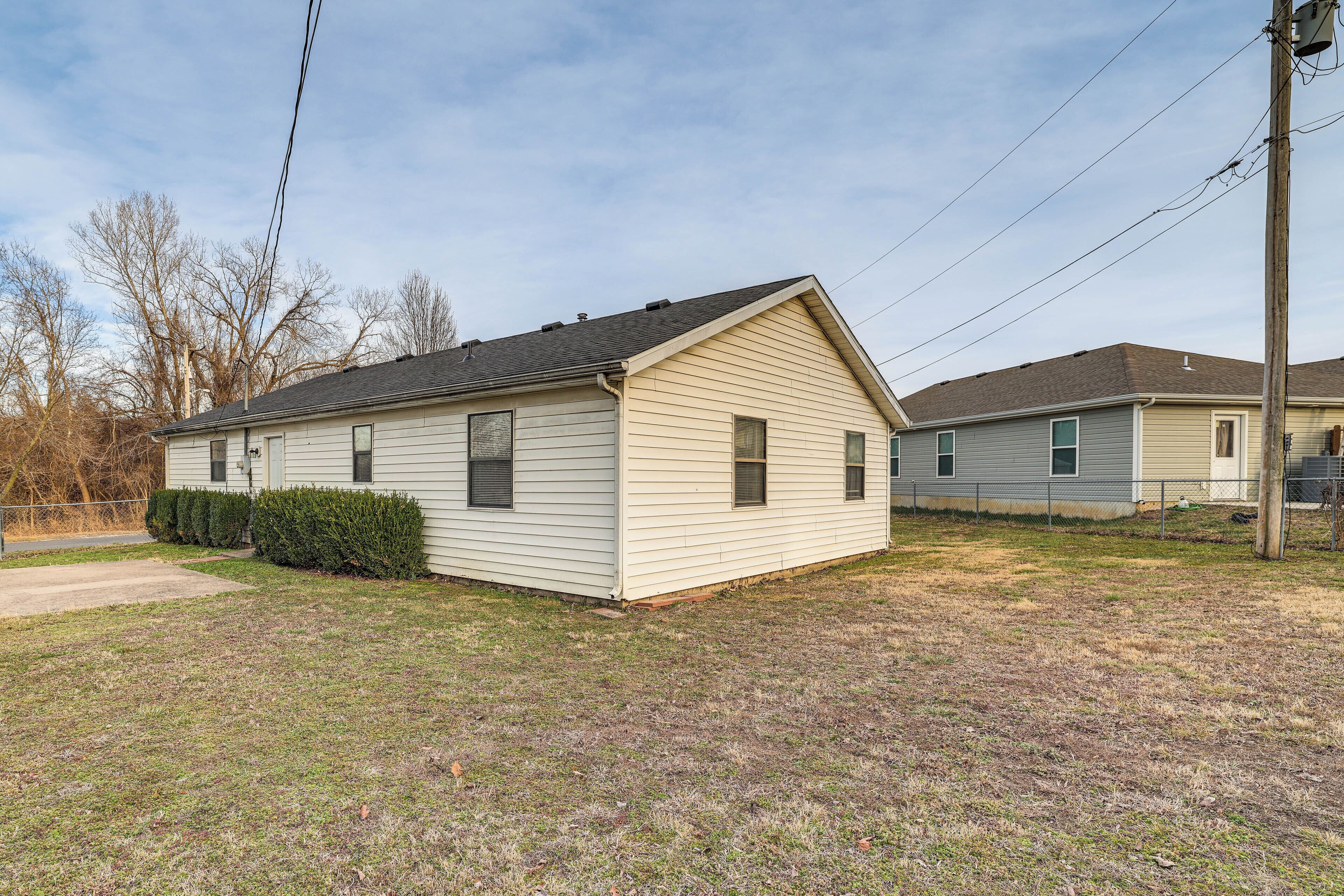 A single-story house with a gabled roof, a front yard, and a neighboring house.