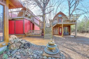 A wooden cabin with a red barn, a wooden deck, and a stone fountain. - Mtn Cabin 1 Mi to Tiec: Outdoor Kitchen + Fire Pit (Mill Spring)