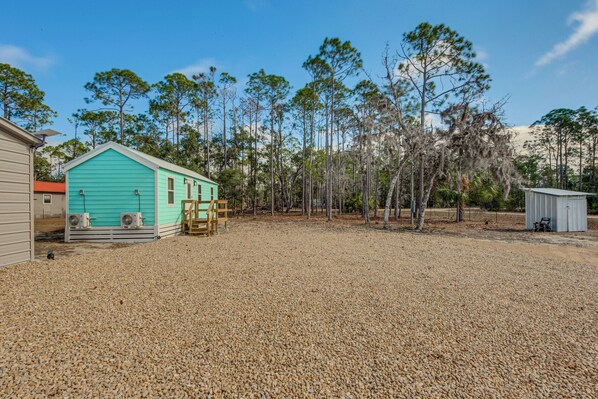 A turquoise building with a gravel driveway, surrounded by trees and a small shed. - 7 Mi to Keaton Beach: Peaceful Perry Gem! (Perry)