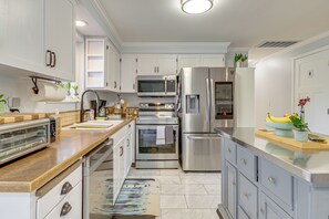 A modern kitchen with white cabinets, stainless steel appliances, and a wooden countertop. - 2 Mi to Wineries! Woodinville Home w/ Deck & Yard (Woodinville)
