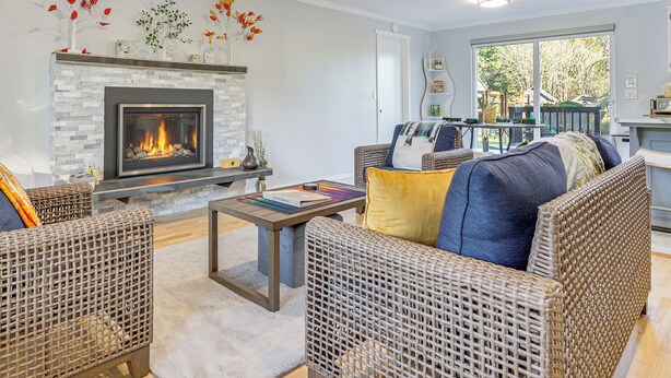 A living room with wicker furniture, a fireplace, and a view of the outdoors. - 2 Mi to Wineries! Woodinville Home w/ Deck & Yard (Woodinville)