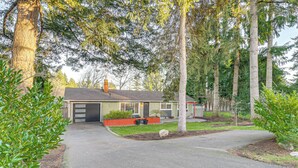 A single-story house with a garage, surrounded by mature trees and a well-maintained lawn. - 2 Mi to Wineries! Woodinville Home w/ Deck & Yard (Woodinville)