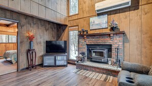 A living room with a fireplace, a television, and a sofa. - Poconos Retreat in The Hideout Lake Community! (Lake Ariel)