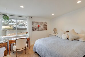 A bedroom with a large bed, a desk with a chair, a window with a view of a vehicle outside, and a painting on the wall. - Stunning Mountain Views! Secluded Retreat in Bend (Bend)