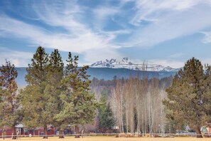 A view of a mountainous landscape with a lake in the background, surrounded by trees and a fenced area. - Stunning Mountain Views! Secluded Retreat in Bend (Bend)