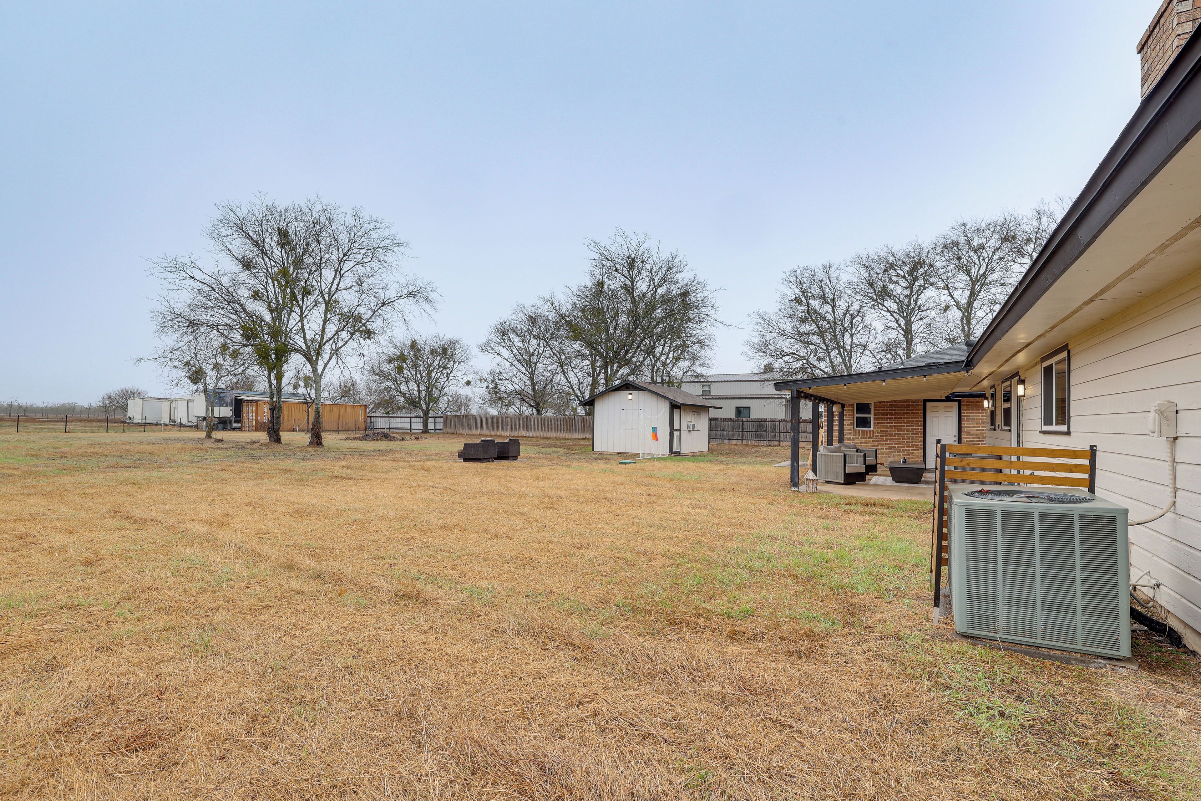 A residential area with a house, a covered porch, and a large air conditioning unit.