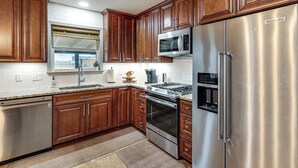 A kitchen with wooden cabinets, stainless steel appliances, and a built-in microwave. - Private Patio & Yard: Pet-friendly Bulverde Home (Bulverde)