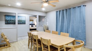 A dining area with a wooden table and chairs, a ceiling fan, and a view into another room. - Private Patio & Yard: Pet-friendly Bulverde Home (Bulverde)