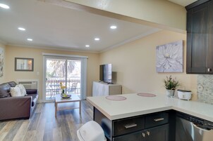 Cocina moderna con una isla central, lavavajillas integrado y comedor con mesa y sillas.